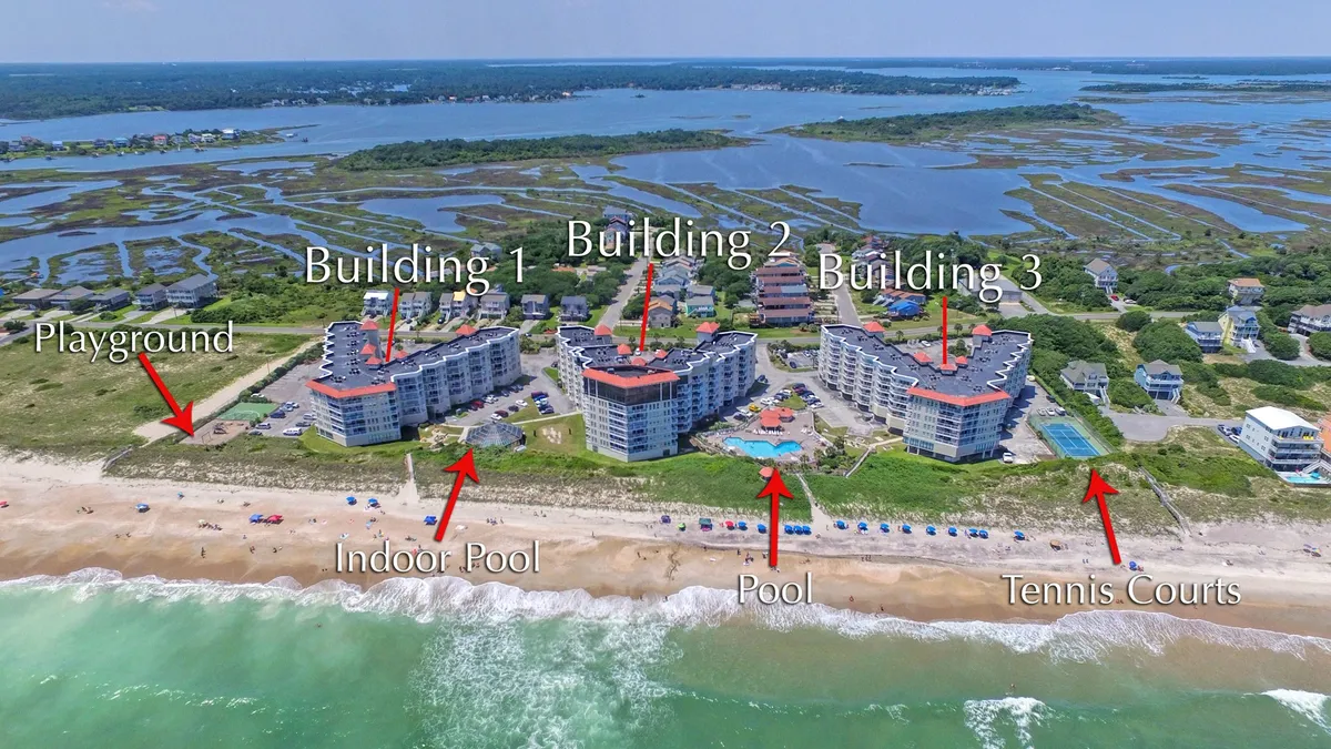 This comprehensive exterior shot captures several resort amenities in one frame, including the indoor and outdoor pools, tennis courts, and playground. The view also shows the buildings and a glimpse of the surrounding recreational landscape, providing a sense of scale and variety offered by the property.